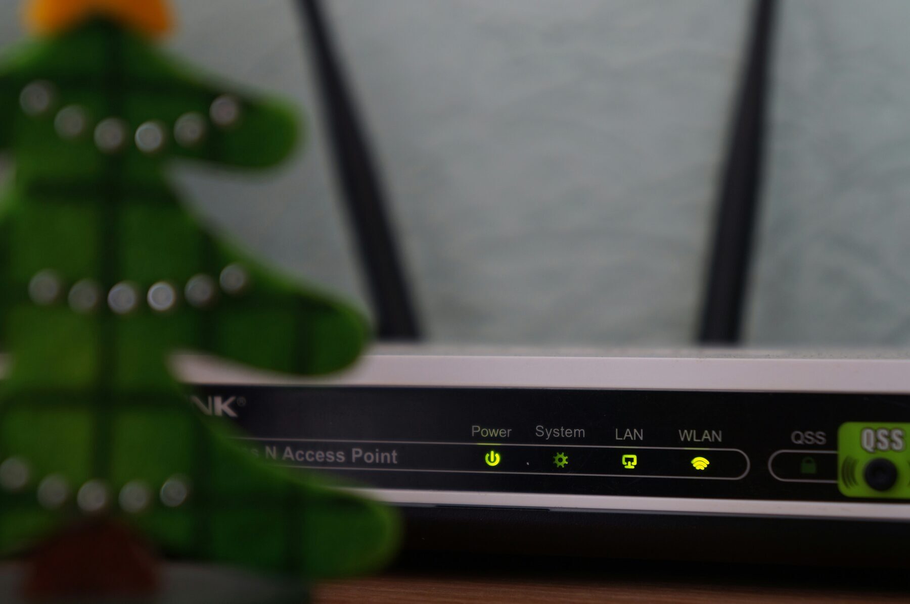 White and black modem router with four status lights illuminated