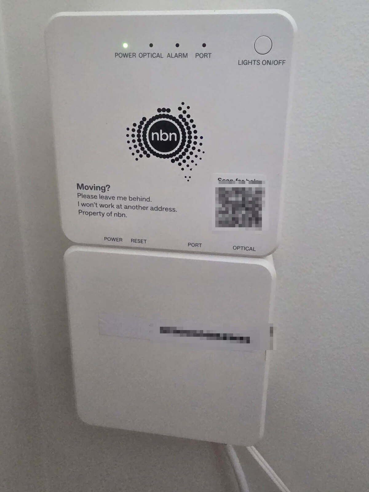 An nbn FTTP connection box (NTD) mounted on an interior wall, with POWER, OPTICAL, ALARM and PORT labels