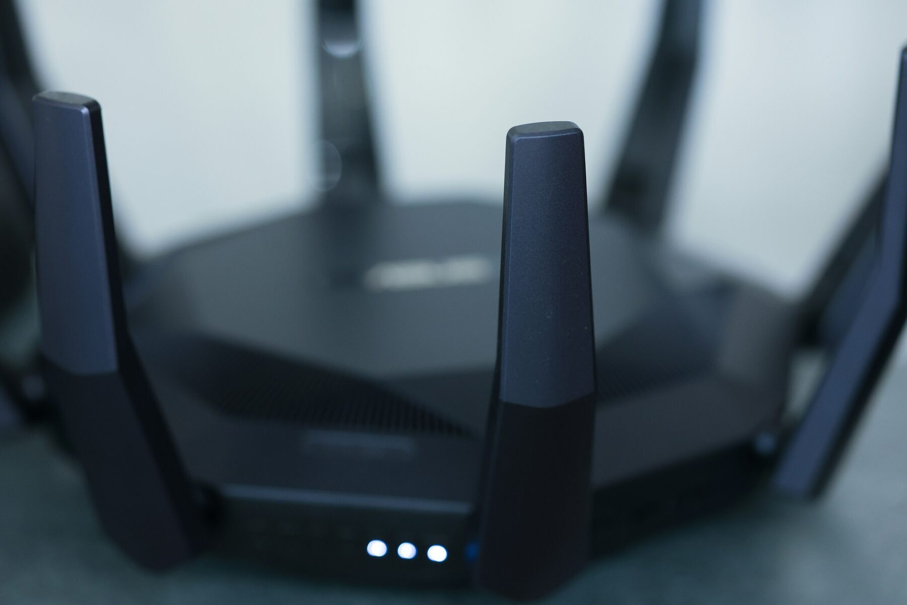 Close-up of a WiFi router showing antennas and glowing LED indicator lights